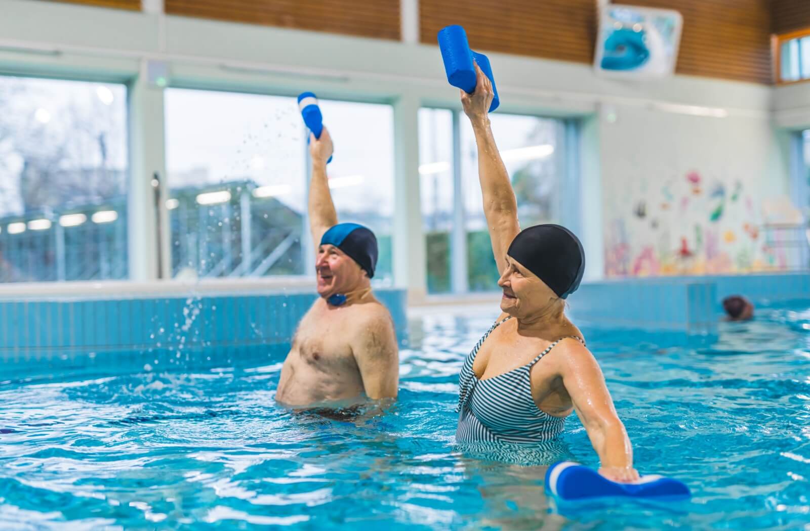 A senior couple participates in water aerobics to keep themselves fit and active.